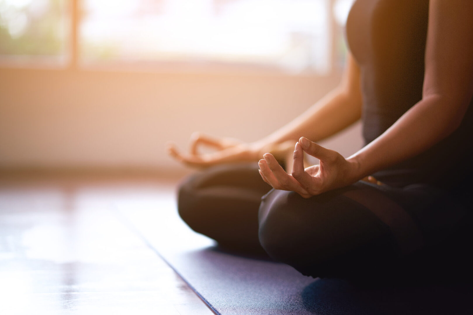 A person sitting on the ground in a yoga pose.