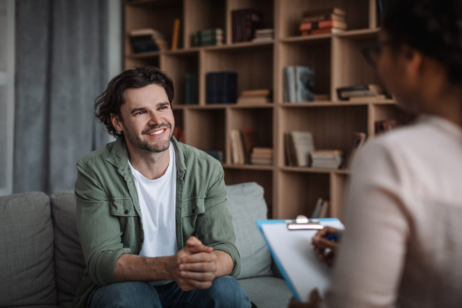 A man sitting on the couch talking to someone