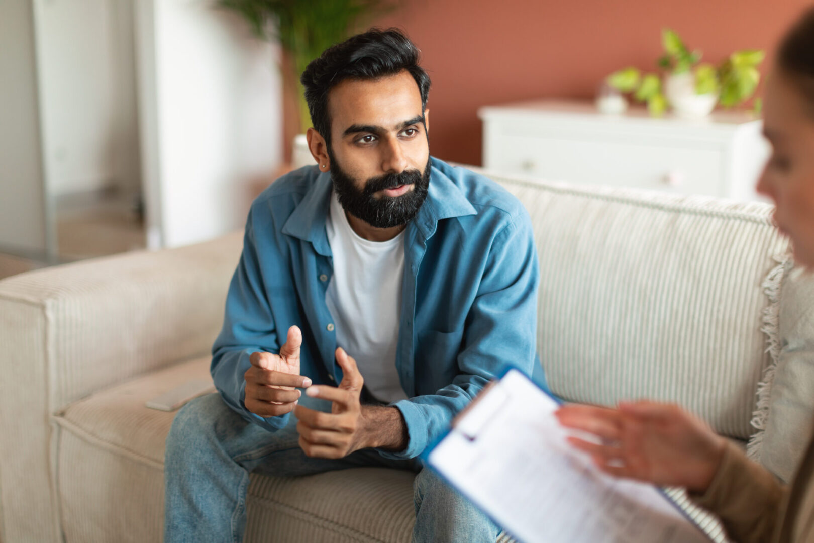 A man sitting on the couch talking to someone