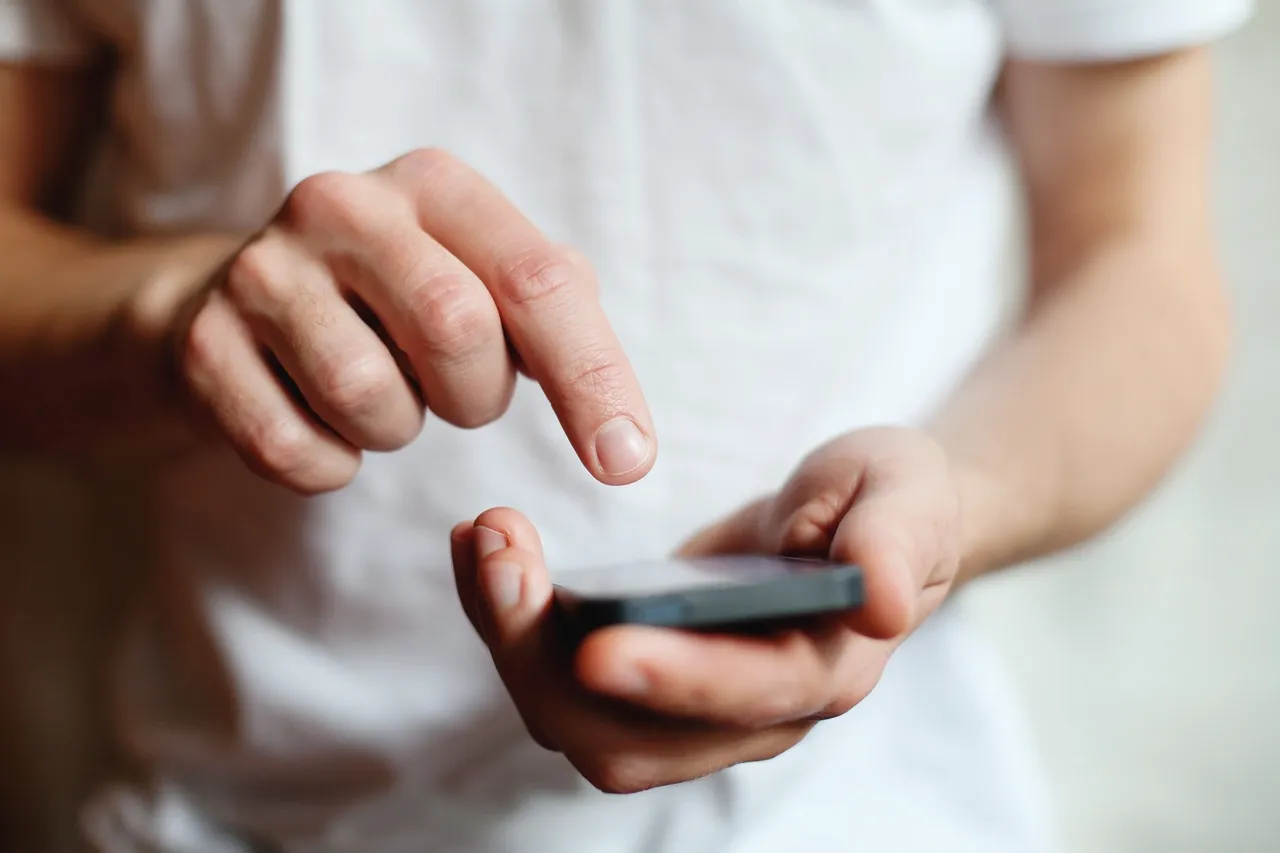 A person holding an electronic device in their hands.